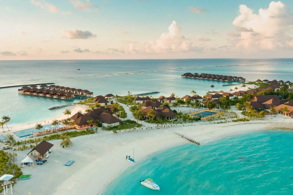 Stunning aerial view of a luxurious tropical resort in the Maldives, showcasing overwater bungalows and turquoise waters.
